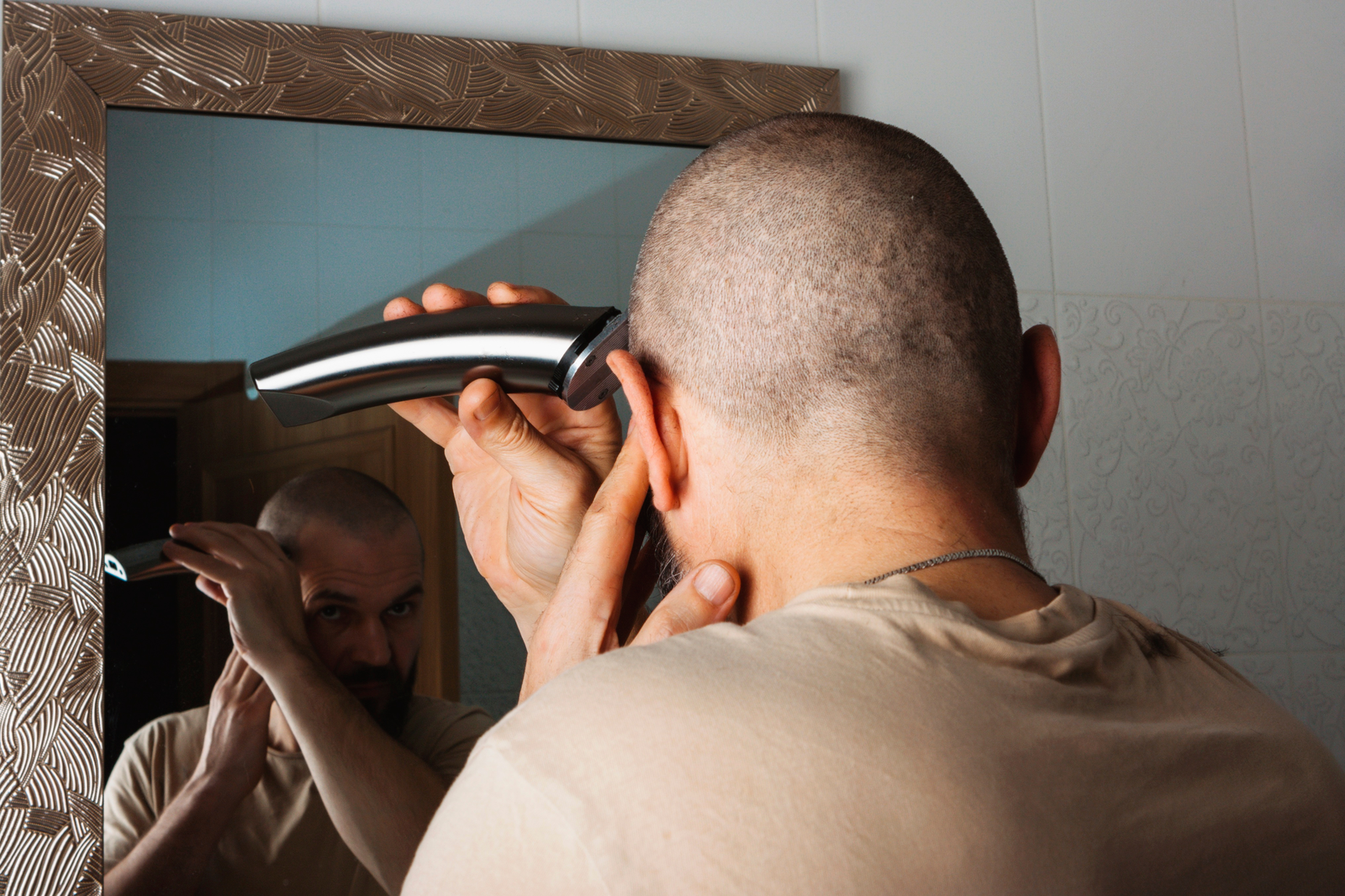 bald guy shaving with hair clipper