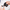 Hands holding a black electric shaver with an interchangeable clipper attachment being removed.