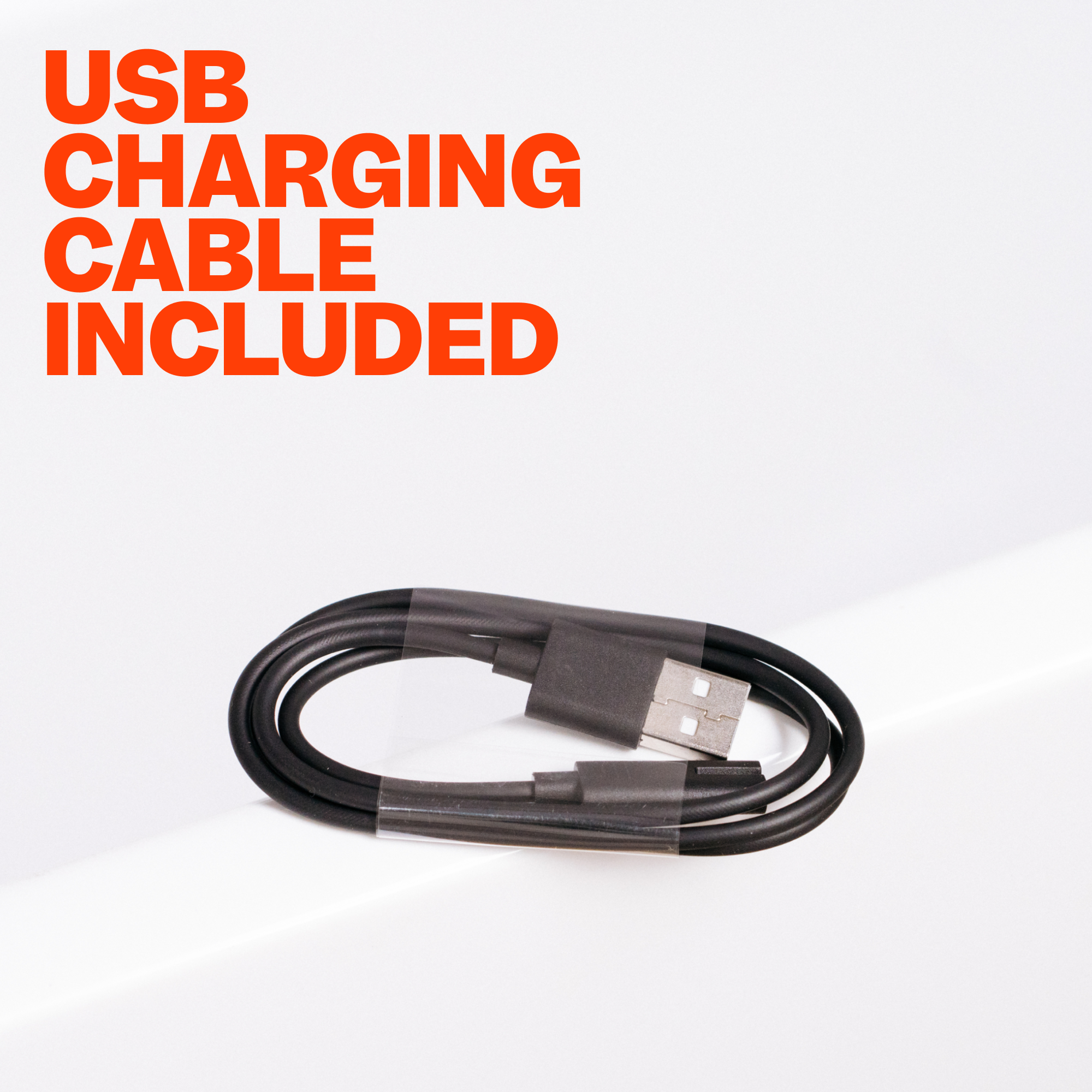 Coiled black USB charging cable on light surface with text
