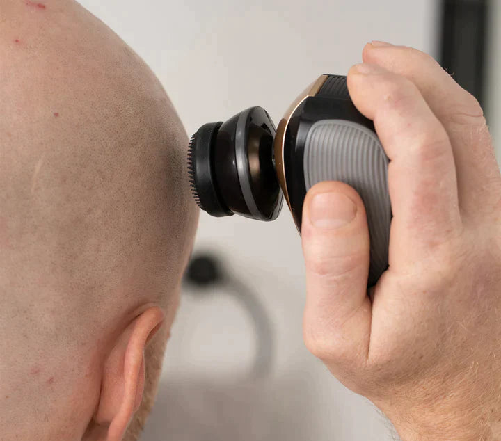 A person shaves their bald head smooth with the Freebird FlexSeries® Shaving Kit featuring ScalpSafe™ Technology.