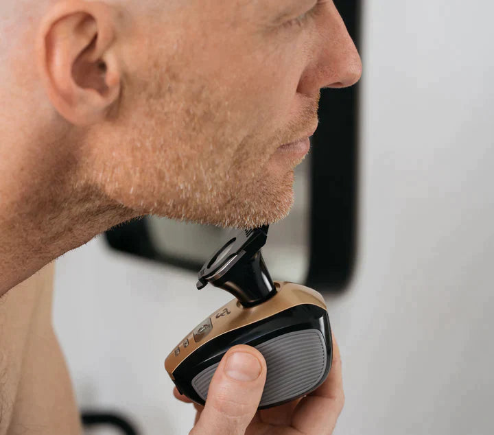 Man shaving his chin with the Freebird FlexSeries® Shaving Kit, featuring ScalpSafe™ Technology, close-up side view.