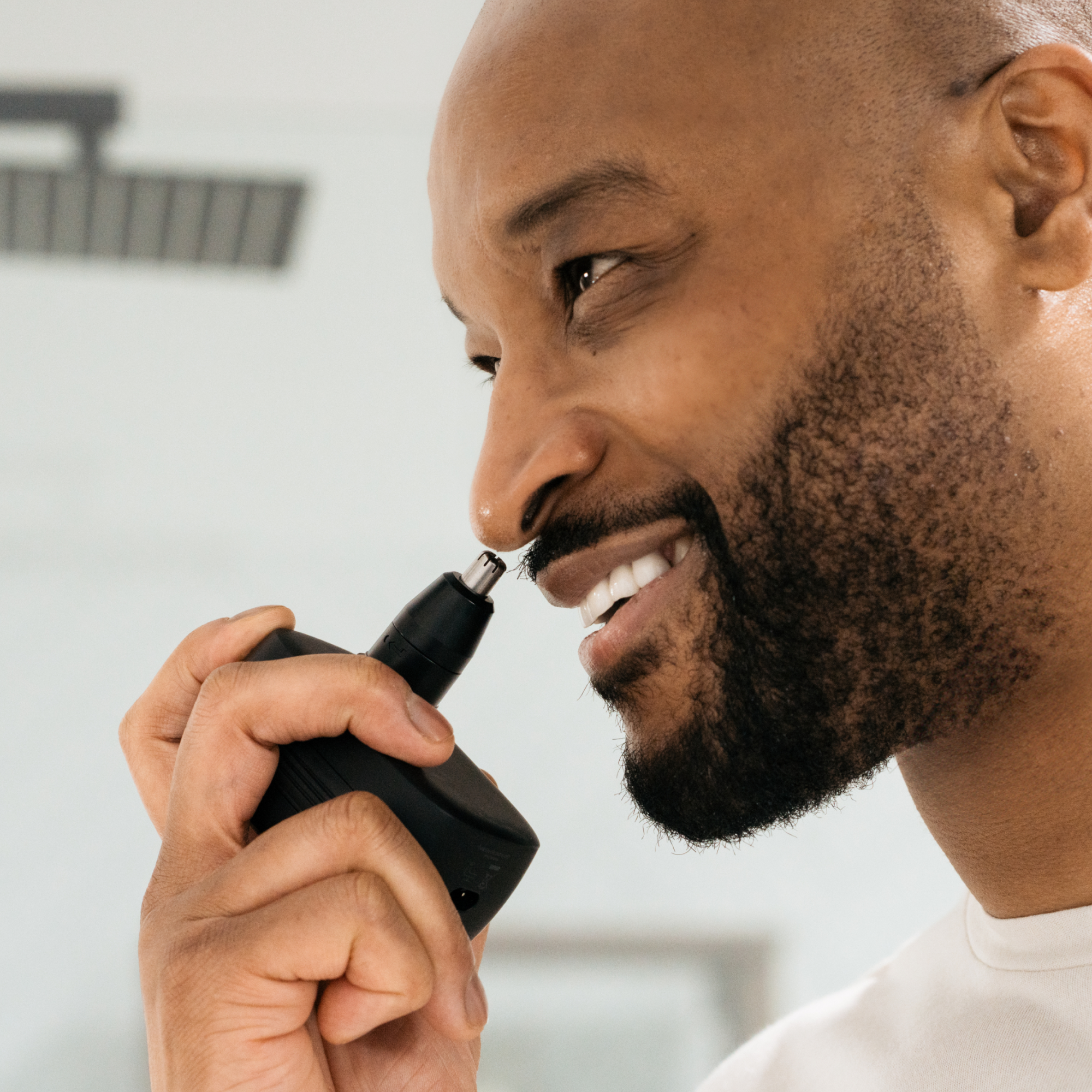 Man smiling in bathroom using Freebirds FlexSeries® Pro Shaving Kit with a Smart Adaptive Motor.